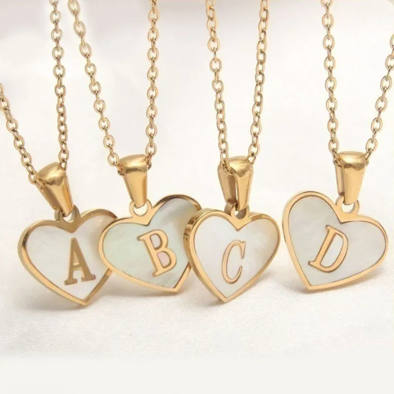 Gold plated heart-shaped necklace with a personalised initial letter and white shell detail on a 50cm adjustable chain.