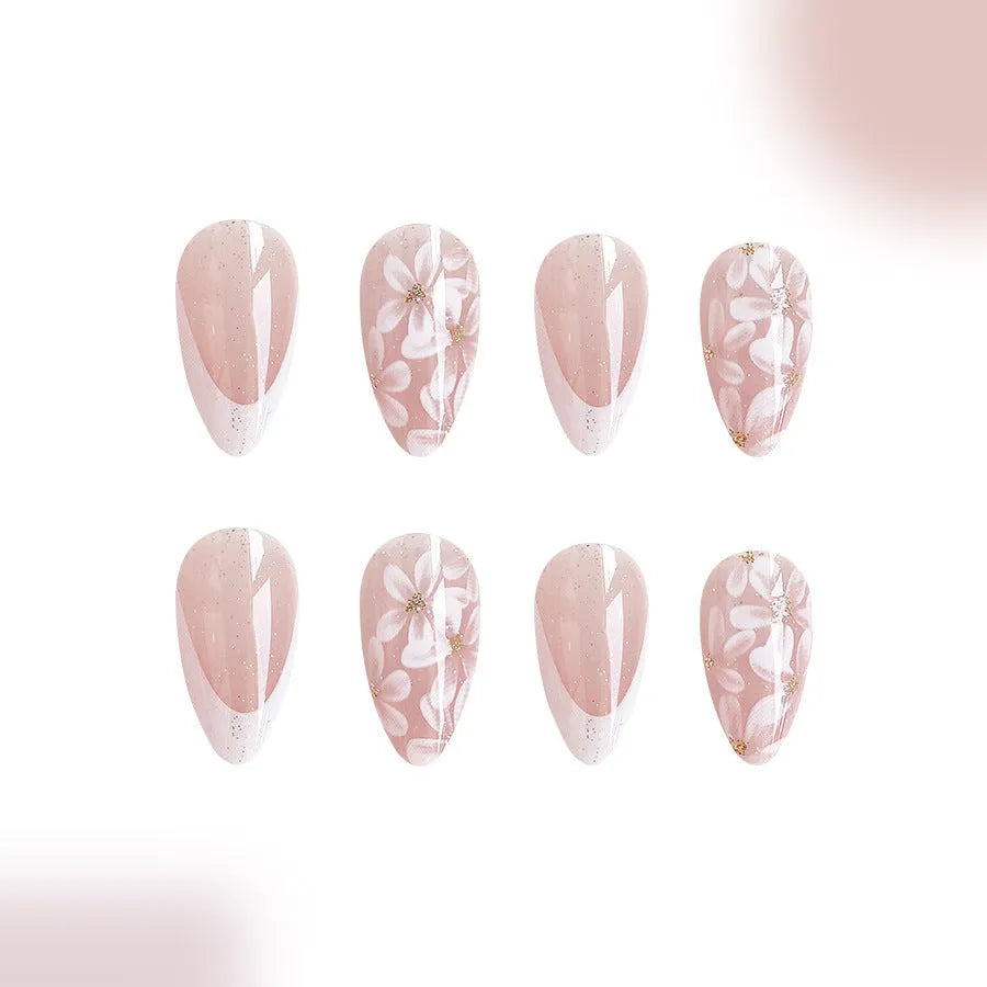 Short almond-shaped false nails with French tips and glitter powder flower decoration