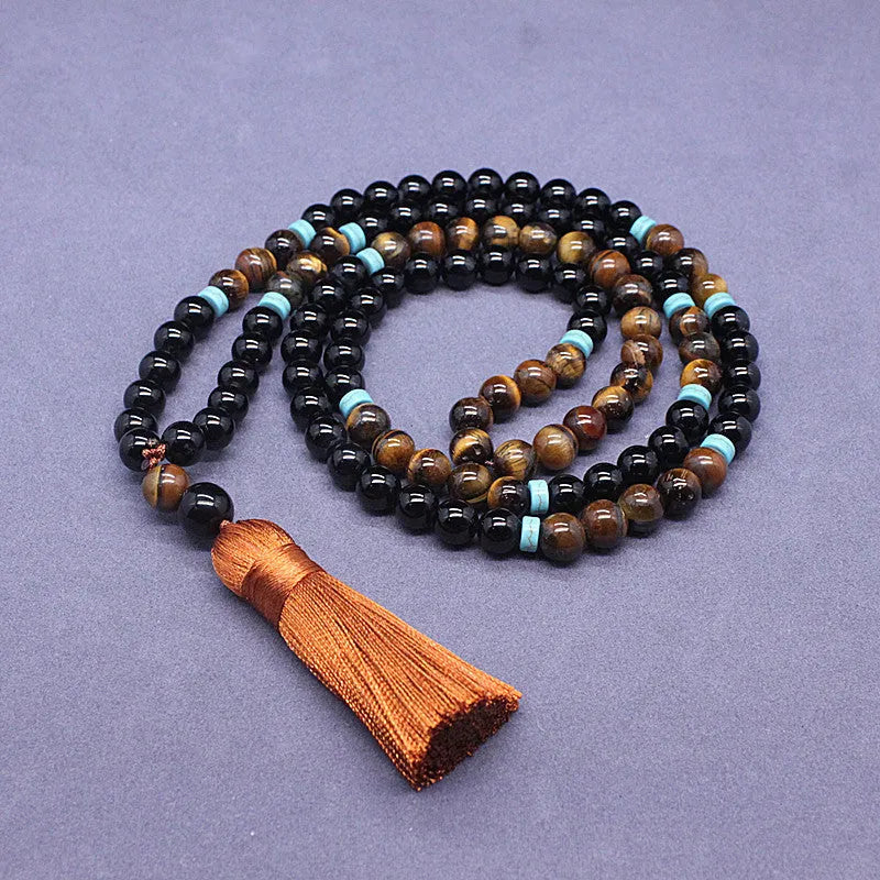 Black agate geometric bead bracelet and matching tiger-shaped tigereye stone necklace set on a grey background.