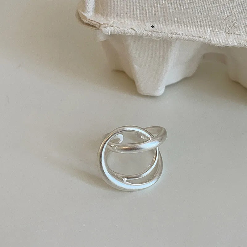 Geometric open ring with interlaced design in matte gold metal finish