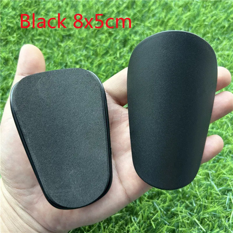 Extra small mini football shin guards measuring 8x5cm in black and white plastic construction