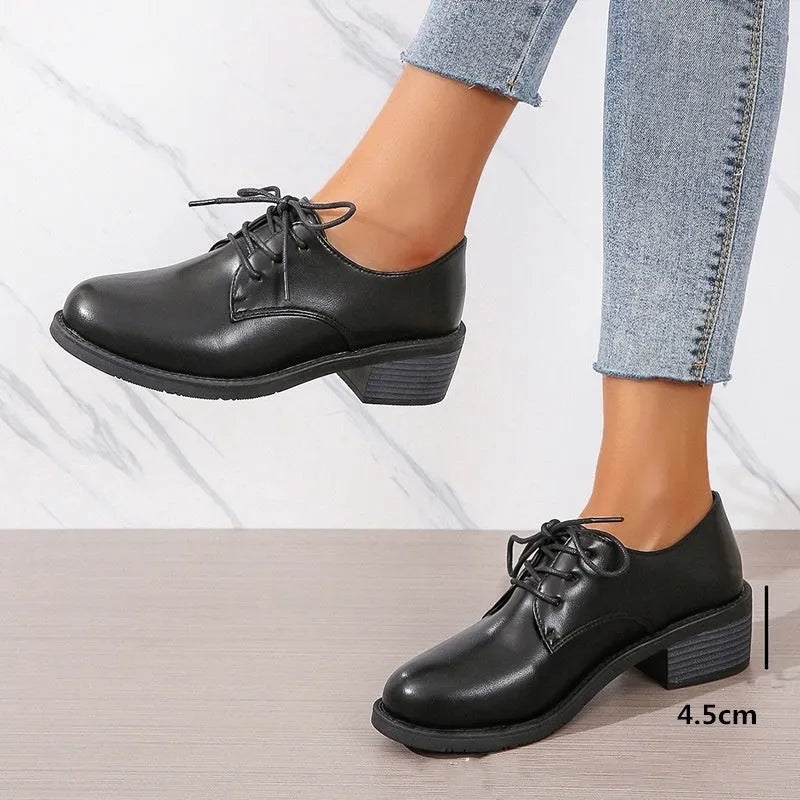Black women's low-top work shoes with a chunky mid heel and soft rubber sole.