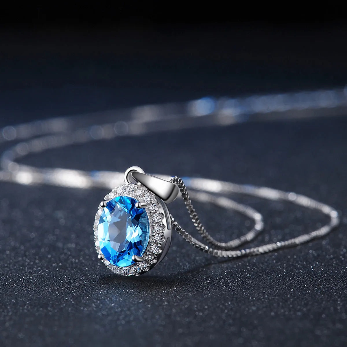 Geometric 925 sterling silver jewellery set with blue topaz stones, showing necklace, earrings, ring, and pendant.