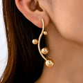 Golden yellow iron ball stud earrings with round shape on a white background