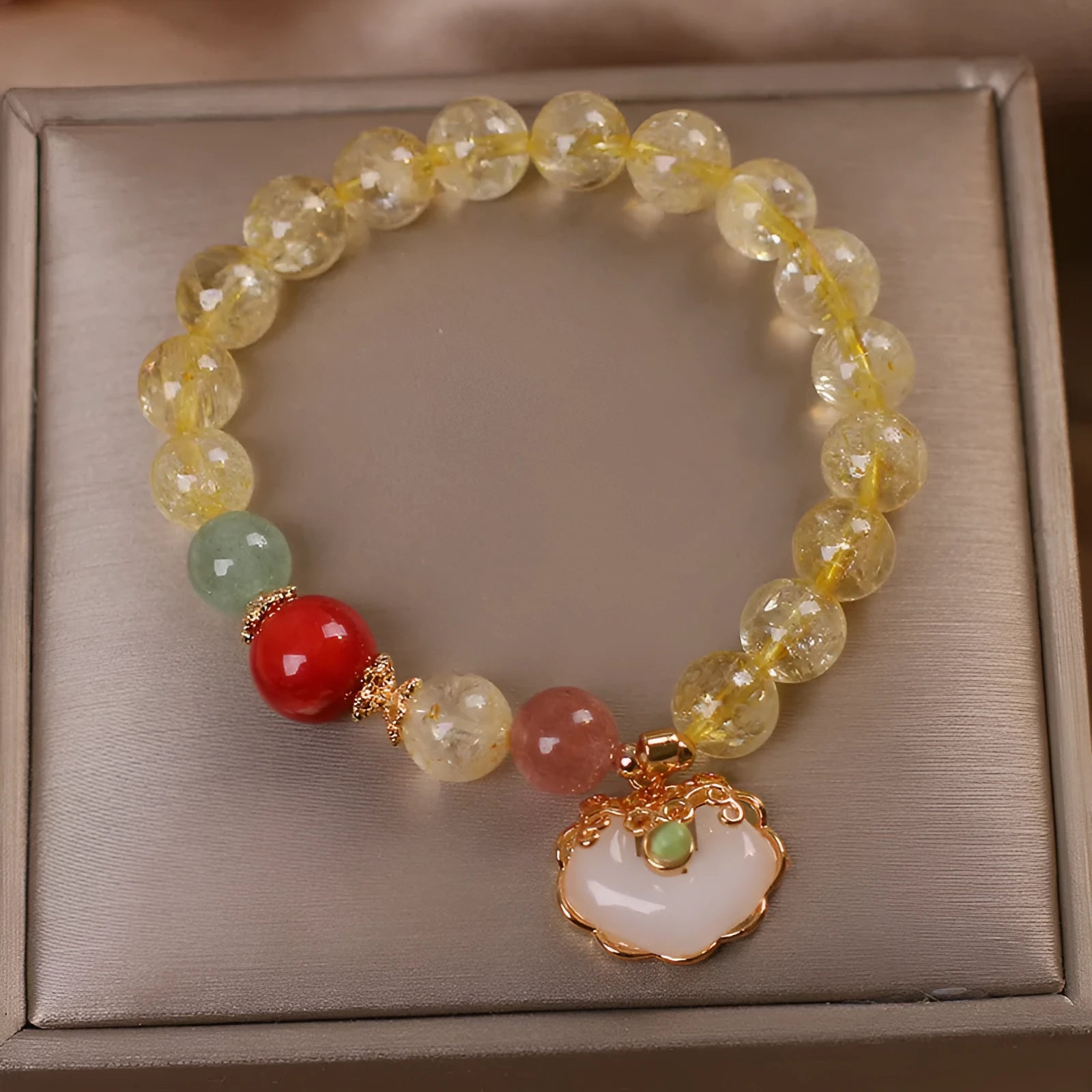 Women's bracelet with a citrine jade ruyi pendant and yellow hair crystal on an alloy band.