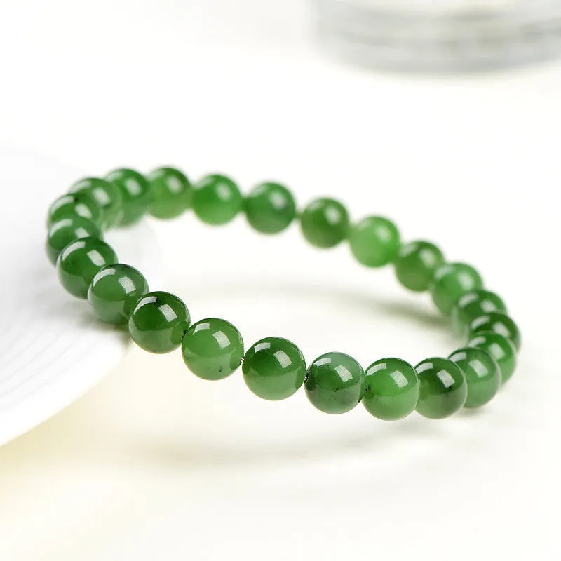 Polished Hetian jade bead bracelet in natural jasper colour on a wrist.