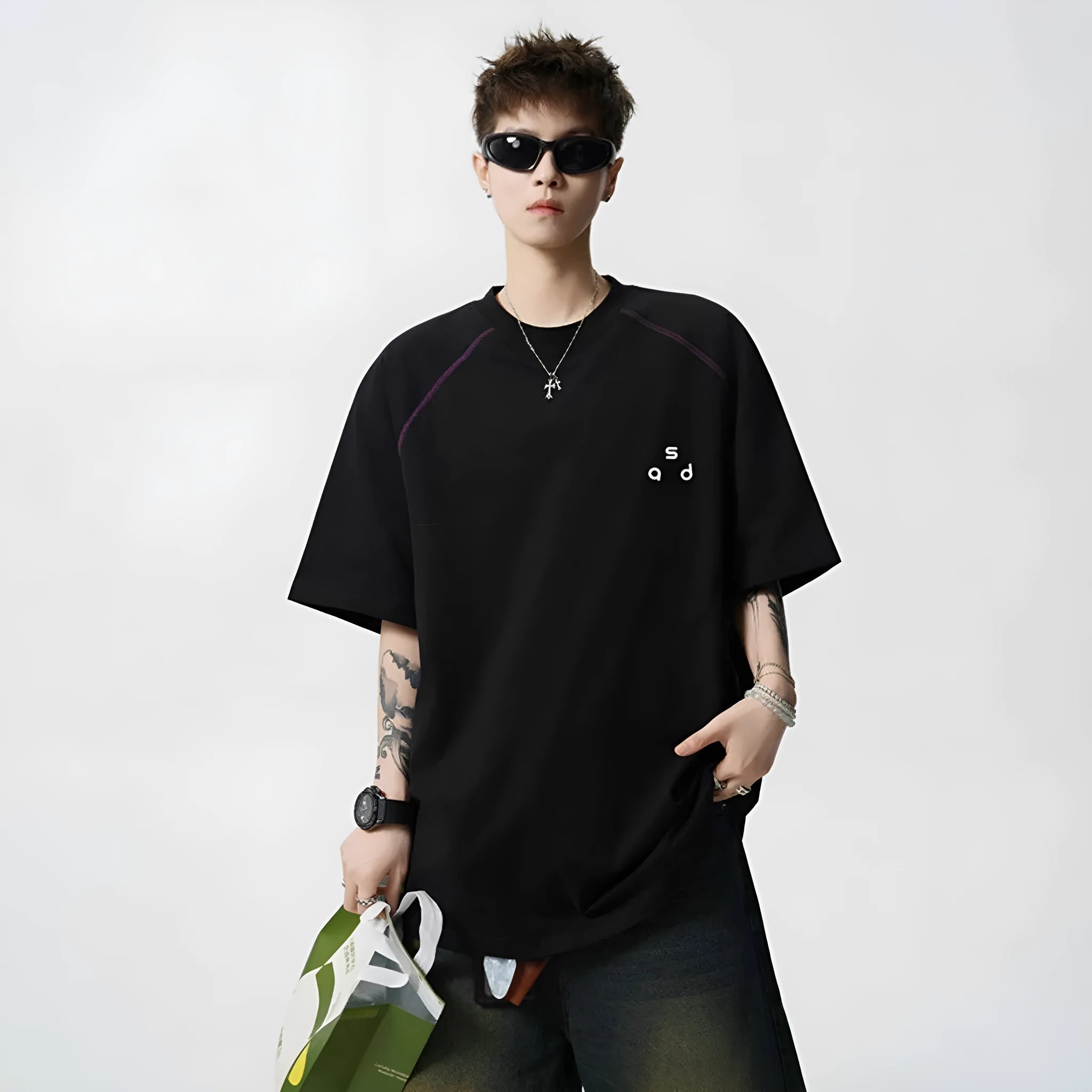 Men's loose-fit black cotton t-shirt with a white printed letter design on the front, showing short sleeves and a round neck.