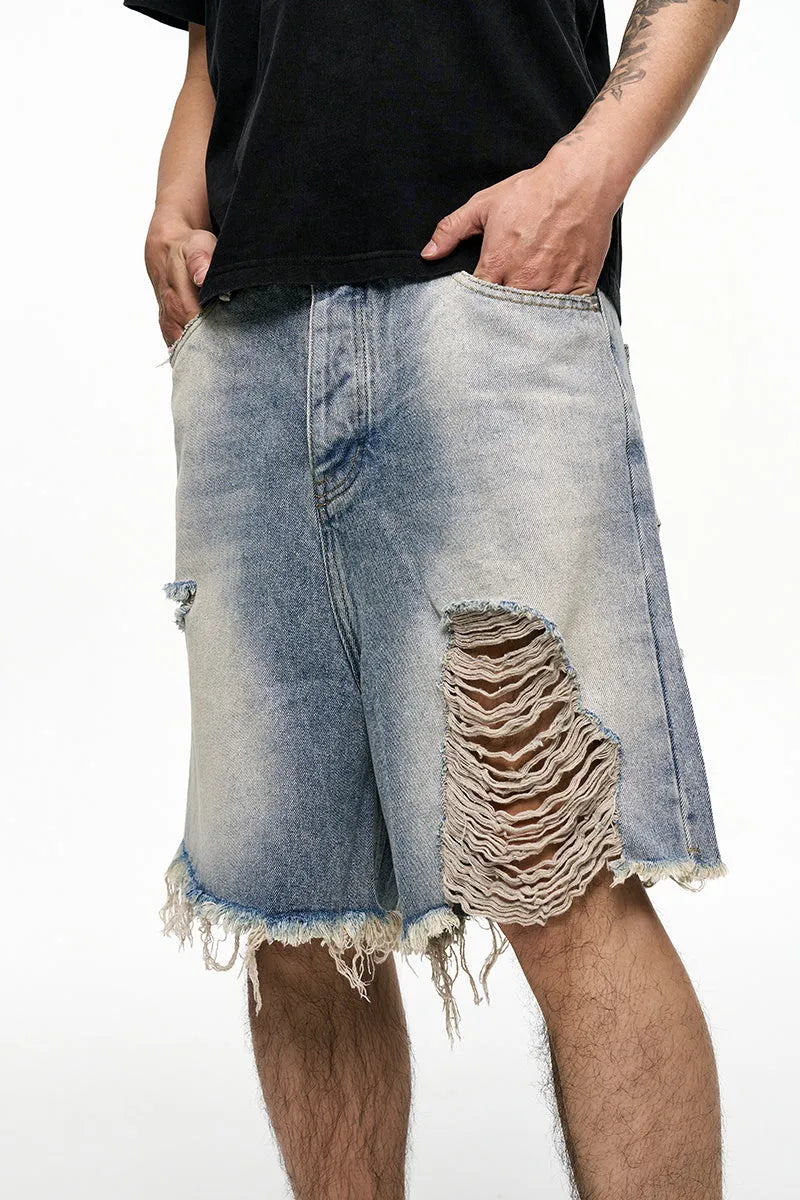 Light blue men's baggy denim shorts with a washed finish and zipper fly on a mid waist.