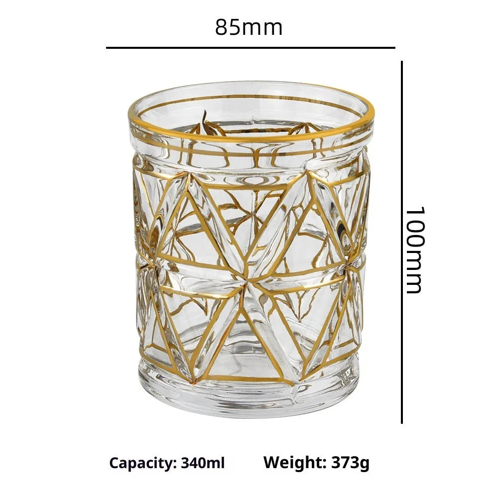 Crystal glass whiskey shot glass with solid gold finish on a bar counter