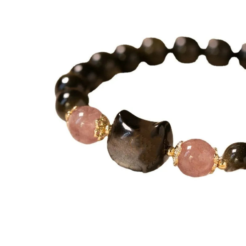 Single circle natural obsidian bracelet with 8mm black beads and kitty cat pendant on white background