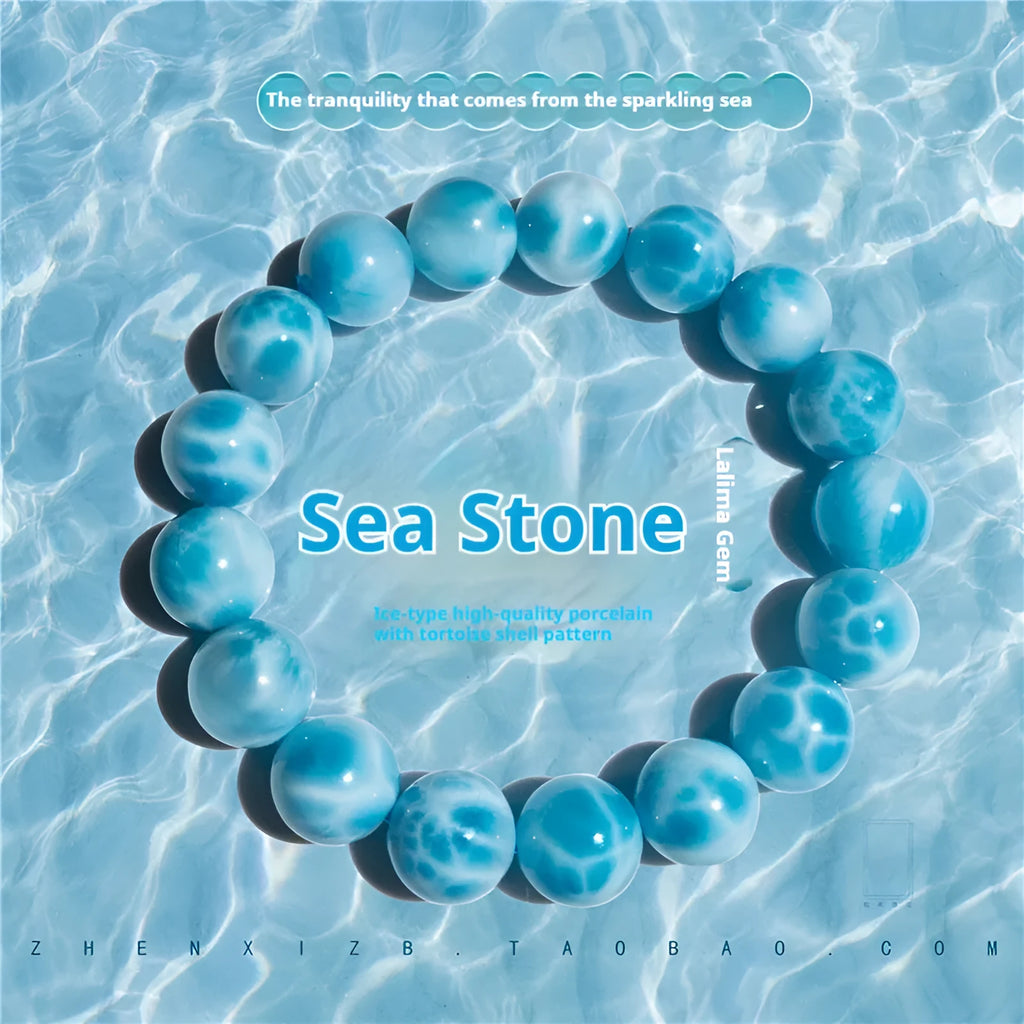 Blue handmade bodhi bracelet with natural crystal sea-pattern beads and pearl accents on a white background.