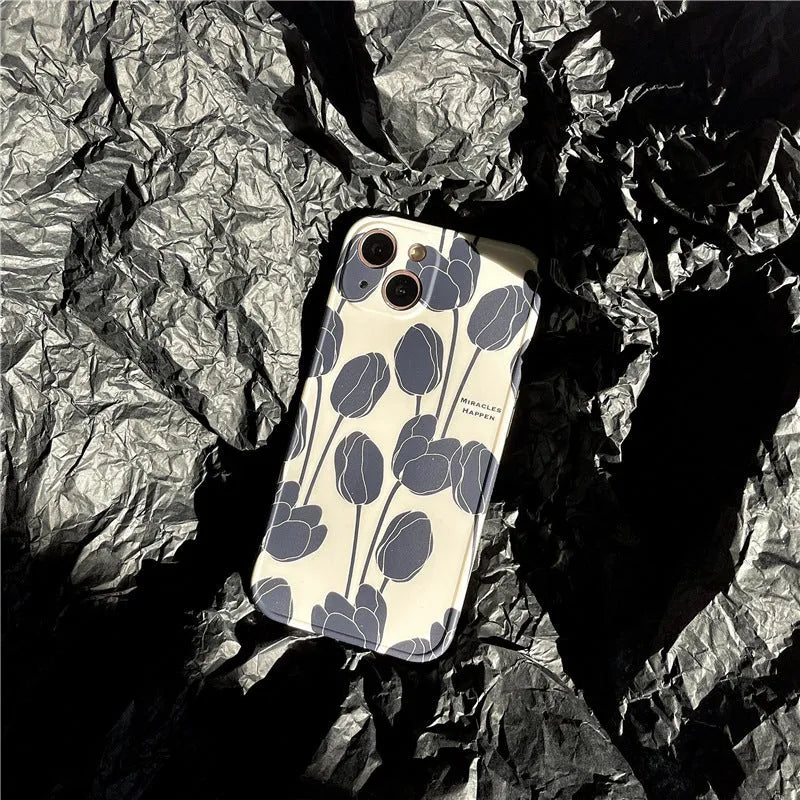 Black silicone iPhone case with a printed white and grey tulip floral design on the back.