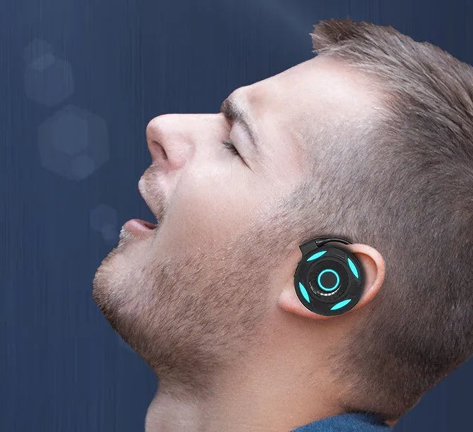 Black Bluetooth gaming earphones with hanging ear design and USB charging cable