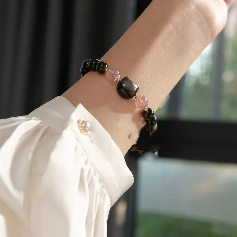 Single circle natural obsidian bracelet with 8mm black beads and kitty cat pendant on white background