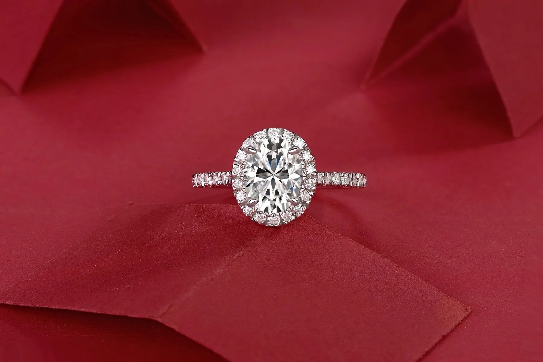 Egg-shaped 7x9mm moissanite wedding ring in S925 silver with platinum plating on white background