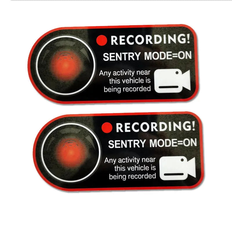 Pair of white electrostatic warning stickers for Tesla Sentry Mode on a car window.
