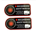 Pair of white electrostatic warning stickers for Tesla Sentry Mode on a car window.