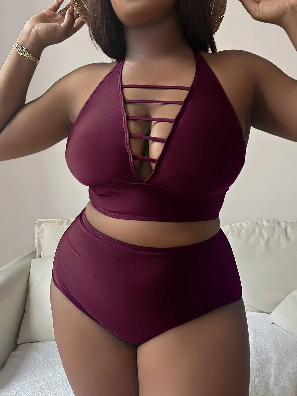 Plus size woman in a black halter bikini with cross shoulder straps and high-waisted briefs.