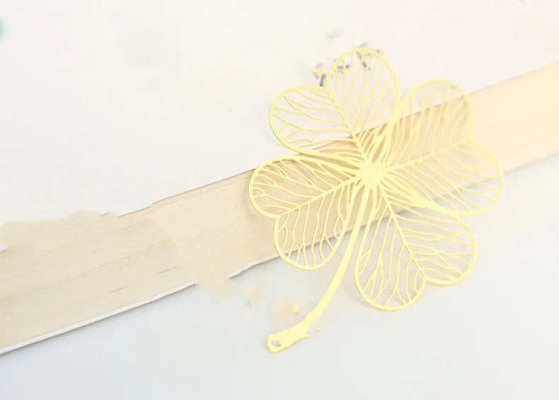 Brass metal bookmark with hollow leaf design and rose gold tassel in a presentation box.