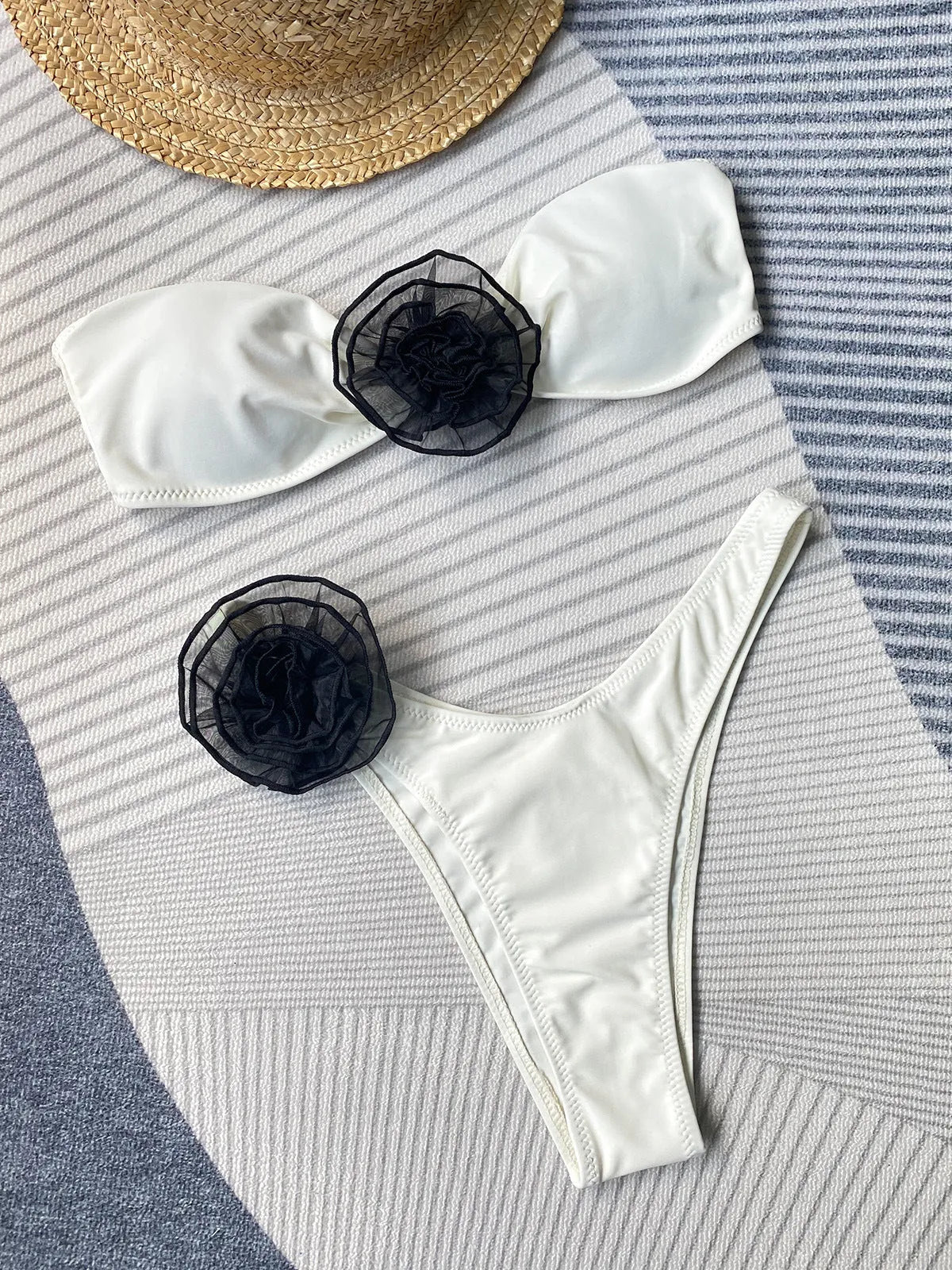 Black floral split bikini swimsuit with a tube top and shorts on a mannequin.