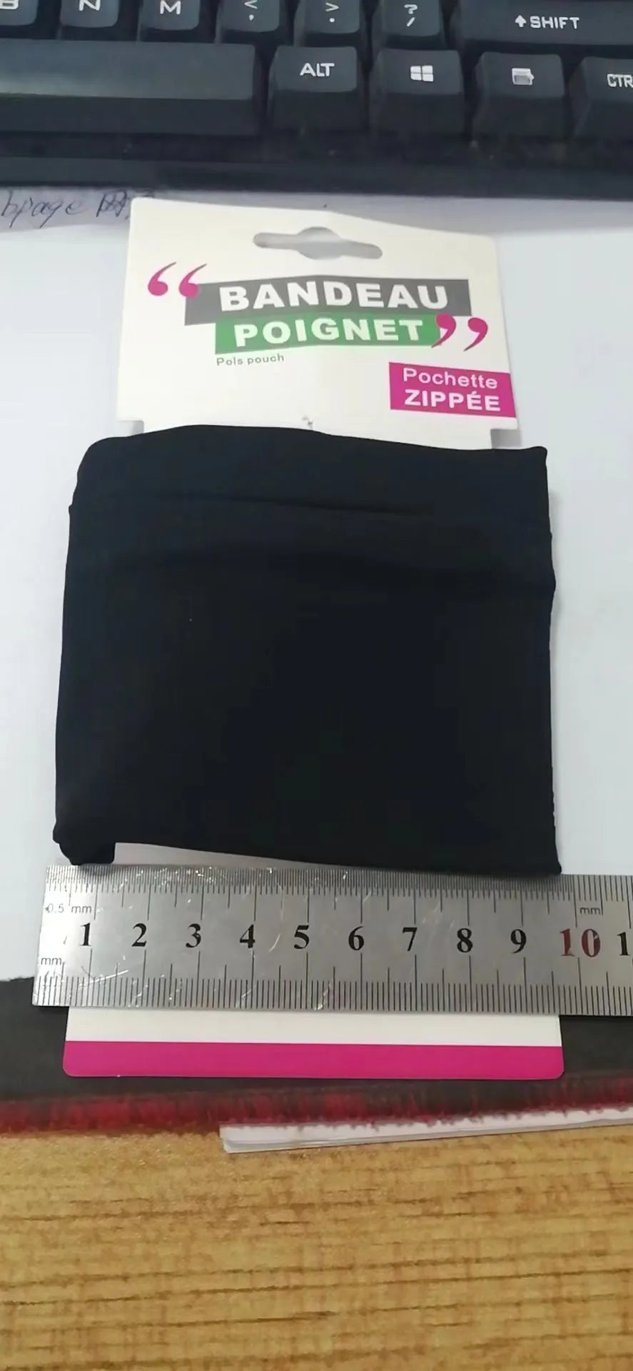 Black wrist bag armband sleeve for mobile phone, shown on an arm, dimensions 10cm by 10.5cm.