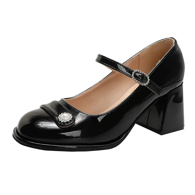 Women's black patent leather chunky heel shoes with round toe and buckle fastening.