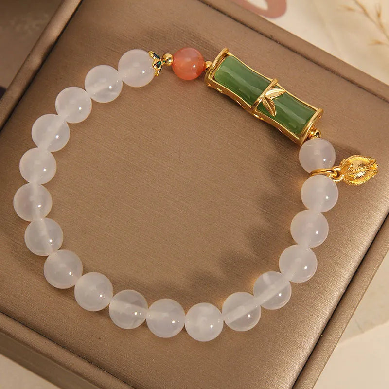 Women's white agate jade bracelet with bamboo joint design and a single bead centrepiece.