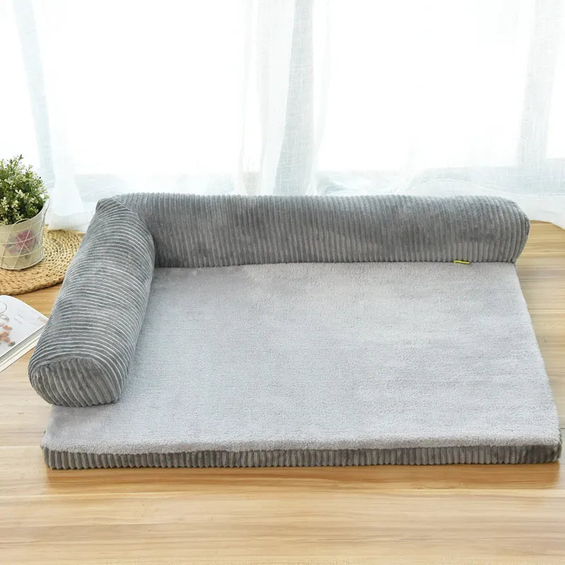 Corduroy pet sofa dog bed with bolster sides, shown in grey colour on a wooden floor