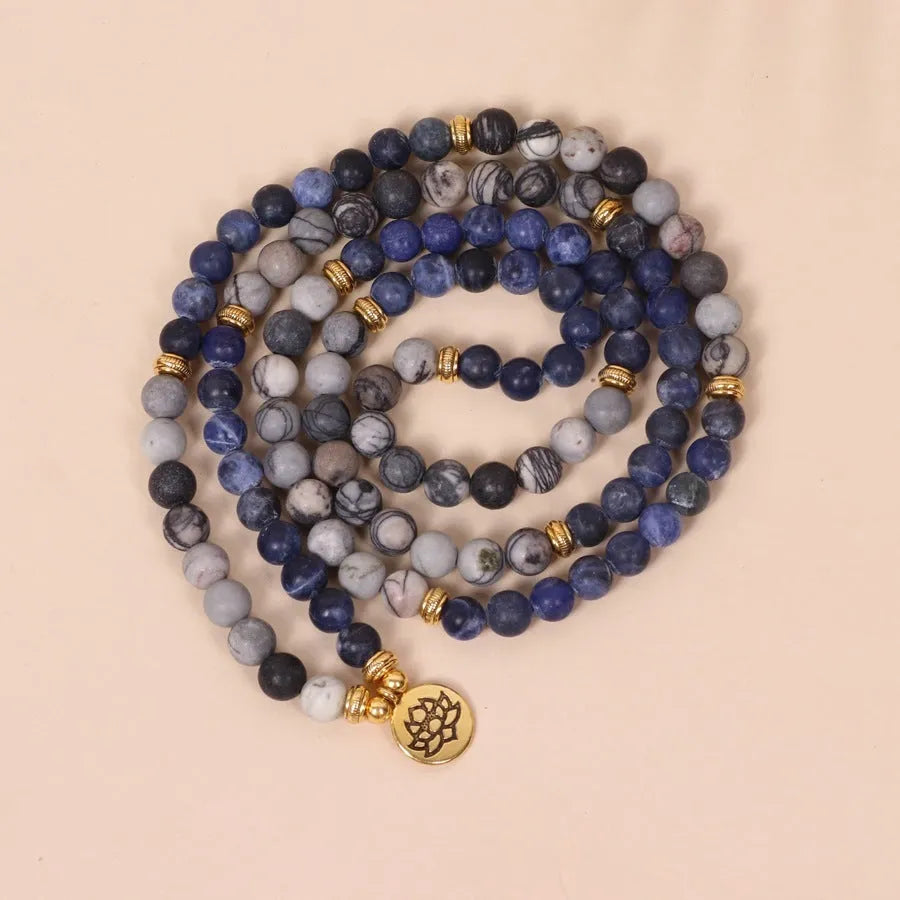 Close-up of a blue multi-layer bracelet with patterned network stone beads and a silver alloy chain.