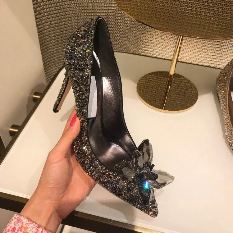 Gold women's pointed toe high heels with rhinestone decoration and a stiletto heel.