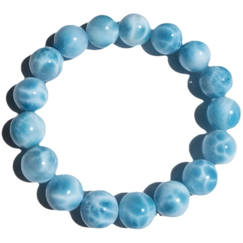 Blue handmade bodhi bracelet with natural crystal sea-pattern beads and pearl accents on a white background.