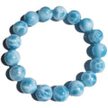 Blue handmade bodhi bracelet with natural crystal sea-pattern beads and pearl accents on a white background.