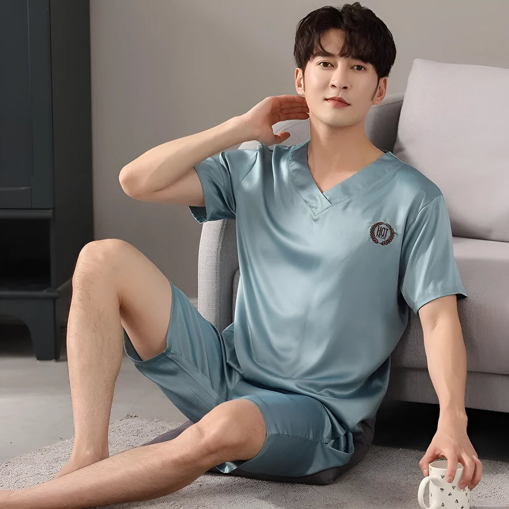 Man wearing a loose blue short-sleeved ice silk pyjama shirt and matching shorts.