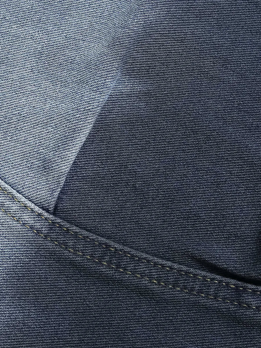 Loose fit blue tie-dye gradient cropped jeans on a hanger, showing washed-out colour and mid-waist design.