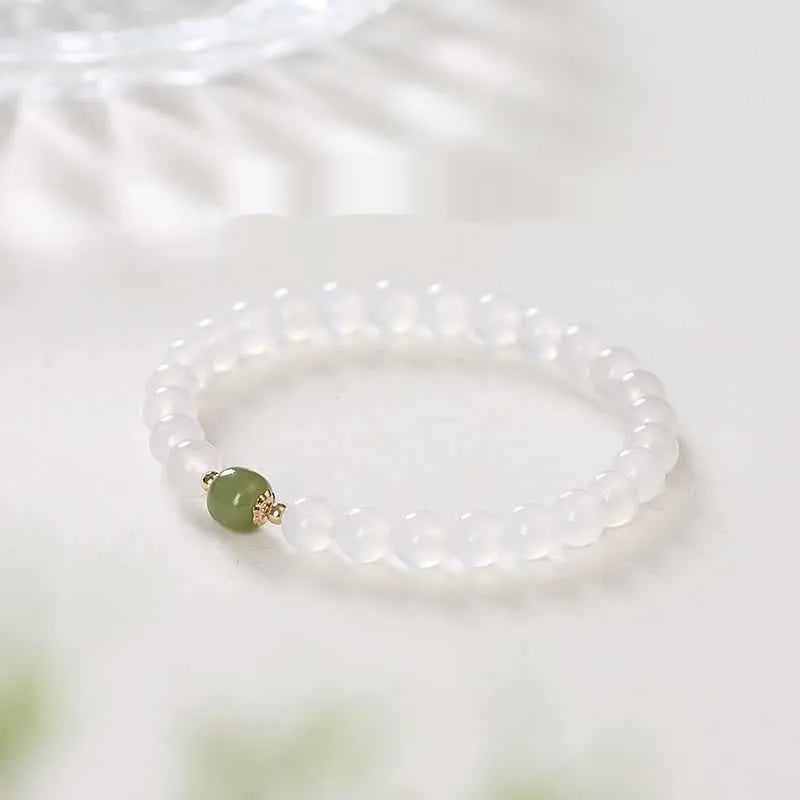 Handmade white agate and crystal bracelet with cinnabar inlay showing letter modelling on 8mm beads.