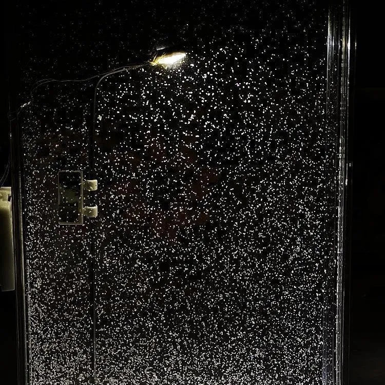 DIY snowy night light kit showing assembled snowflake street lamp scene with warm LED glow on a desktop.