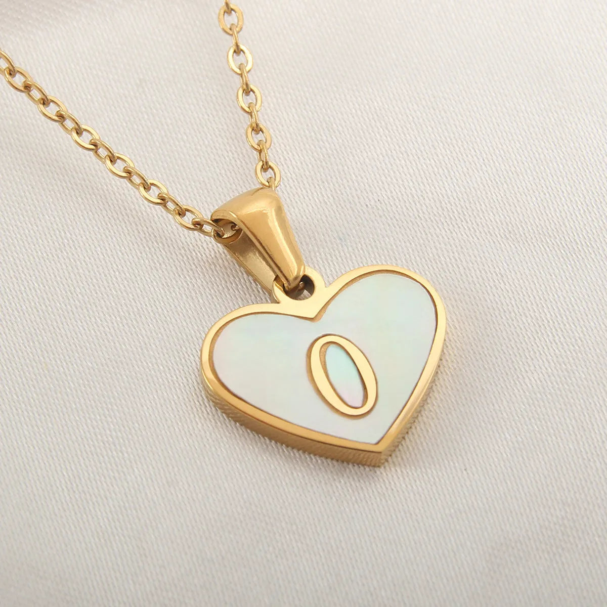 Gold plated heart-shaped necklace with a personalised initial letter and white shell detail on a 50cm adjustable chain.