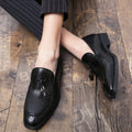 Men's black pointed slip-on leather shoes with a tassel detail on the low-top upper.