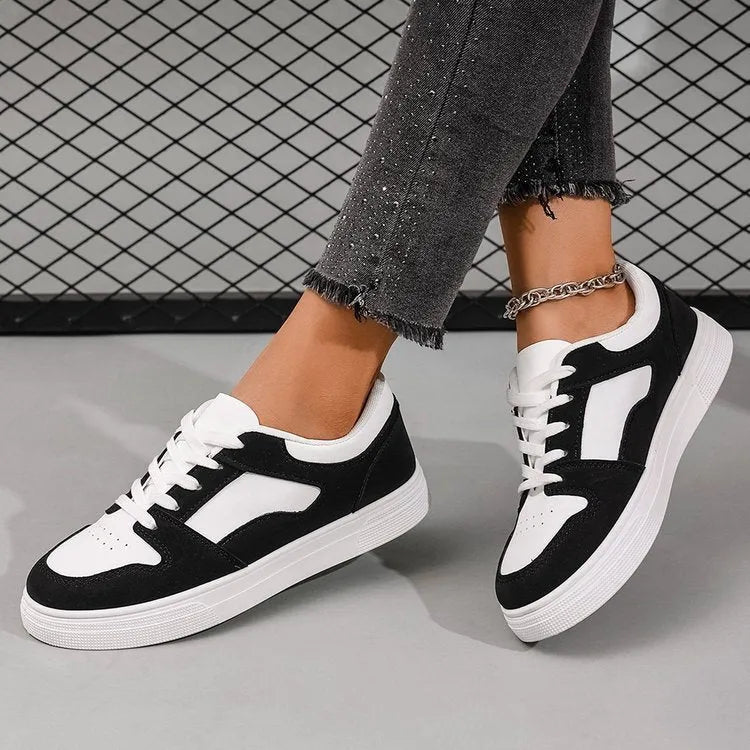 Black women's casual sports shoes with round toe and lace-up front, featuring a low top and flat rubber sole.