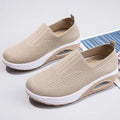 Women's beige artificial PU mesh running shoes with air cushion and round toe on a plain background.