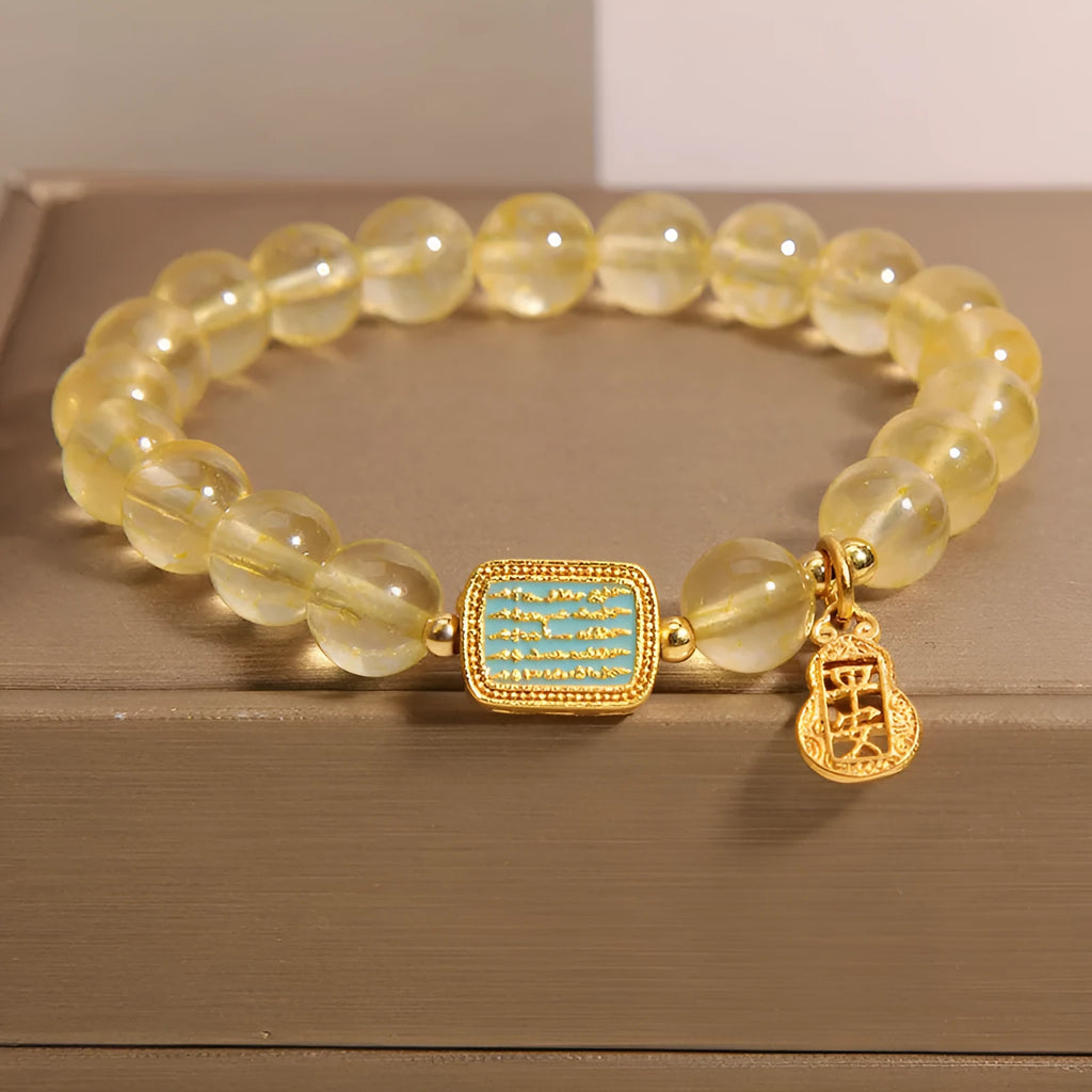 Women's citrine yellow crystal bracelet with rhinestone detailing on a wrist