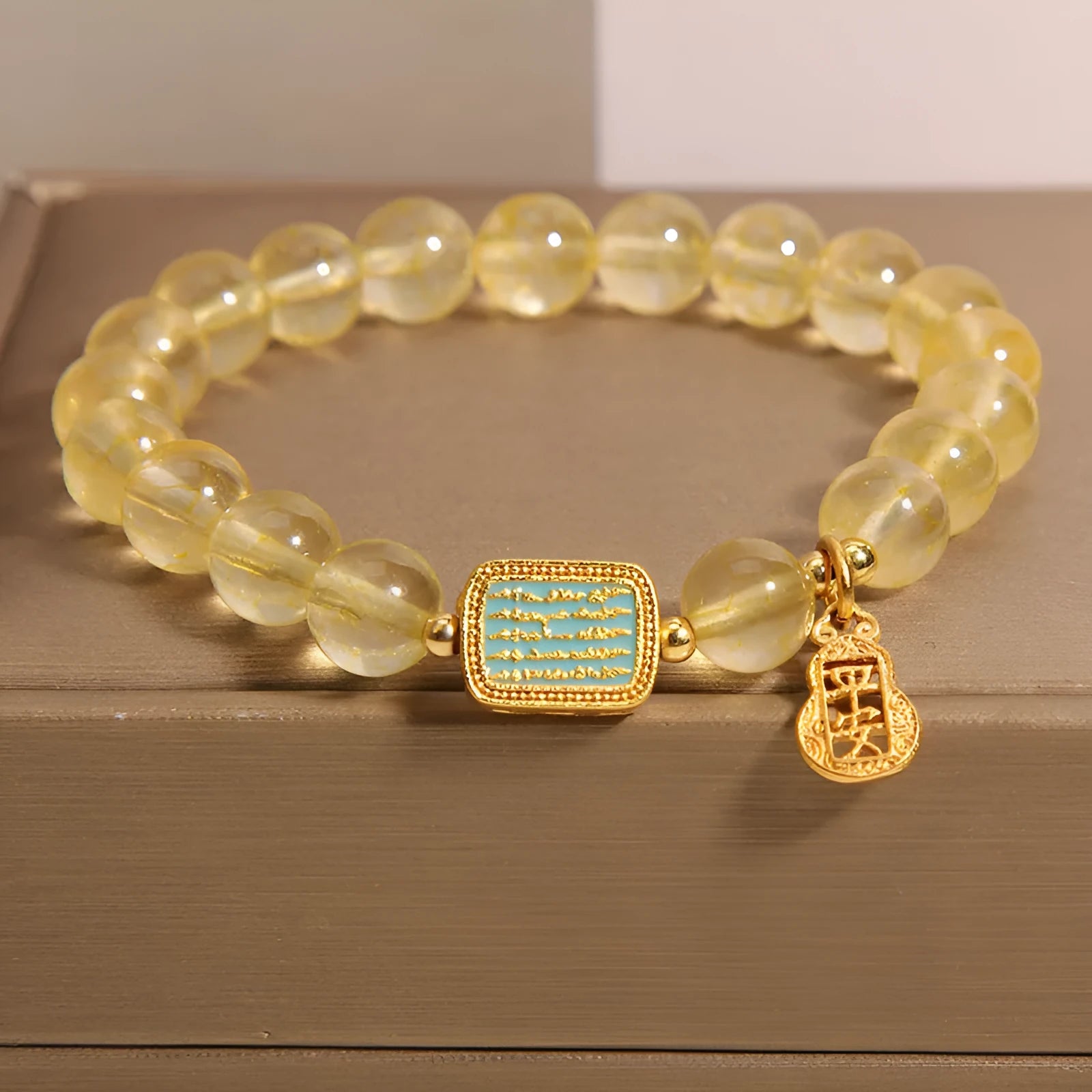 Women's citrine yellow crystal bracelet with rhinestone detailing on a wrist