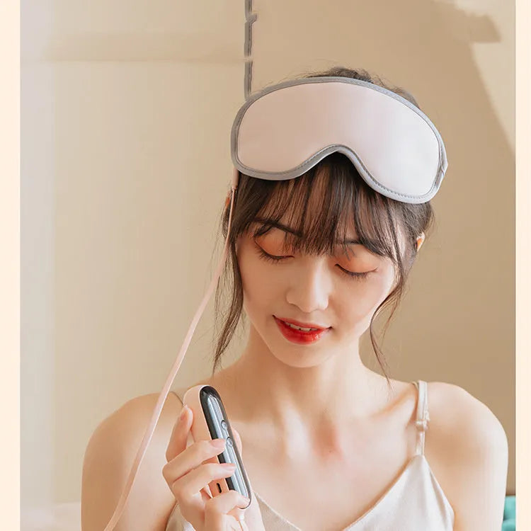 Green portable eye massage mask with USB cable on a grey background