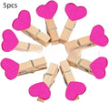 Set of five solid wood heart-shaped clips in red, white, and rose red on a plain surface.