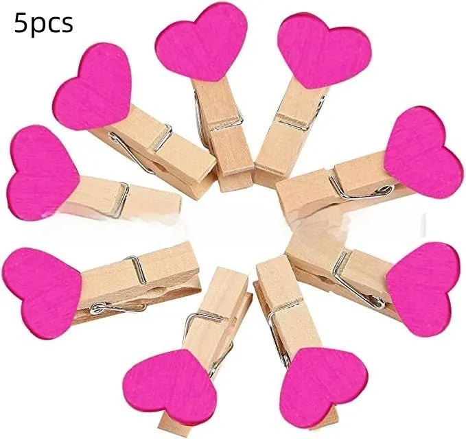 Set of five solid wood heart-shaped clips in red, white, and rose red on a plain surface.
