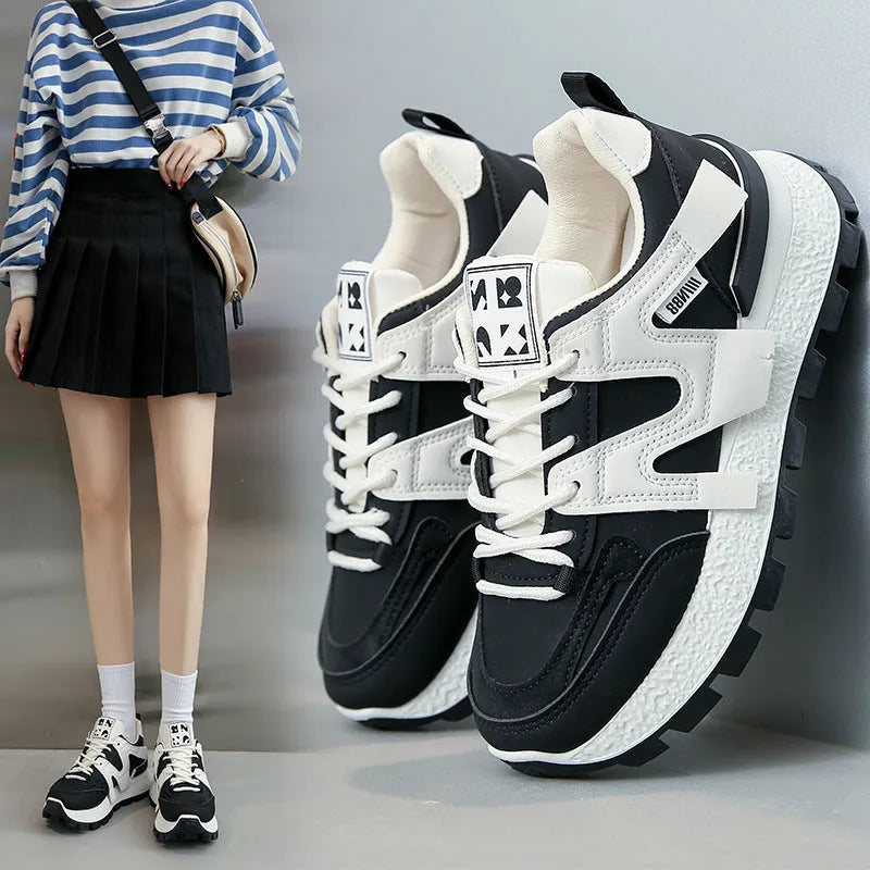 Black and white low-top lace-up sneakers with round toe and rubber sole