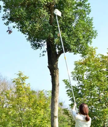 Metal fruit picker with silver ring and cotton bag for picking apples and pears in a garden