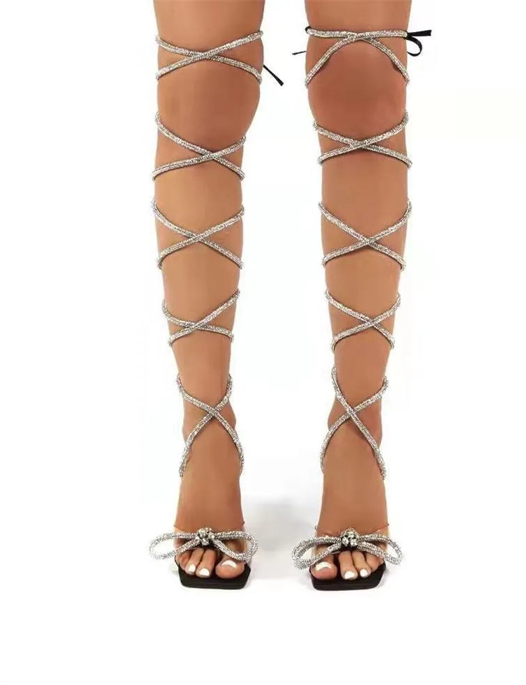 Plus size women's black strappy sandals with rhinestone decoration and a square toe on a rubber sole.
