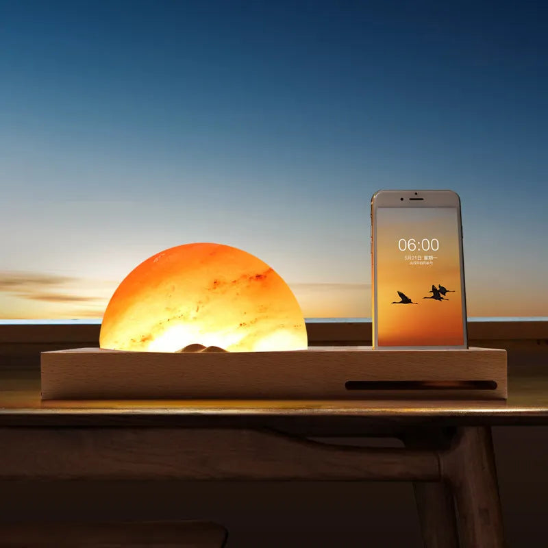 Wooden base Himalayan salt lamp with wireless phone charging pad on top showing warm white glow.