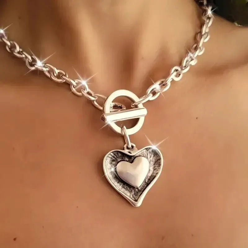 Titanium steel heart pendant necklace with water wave chain on model – stainless steel colour, clavicle length